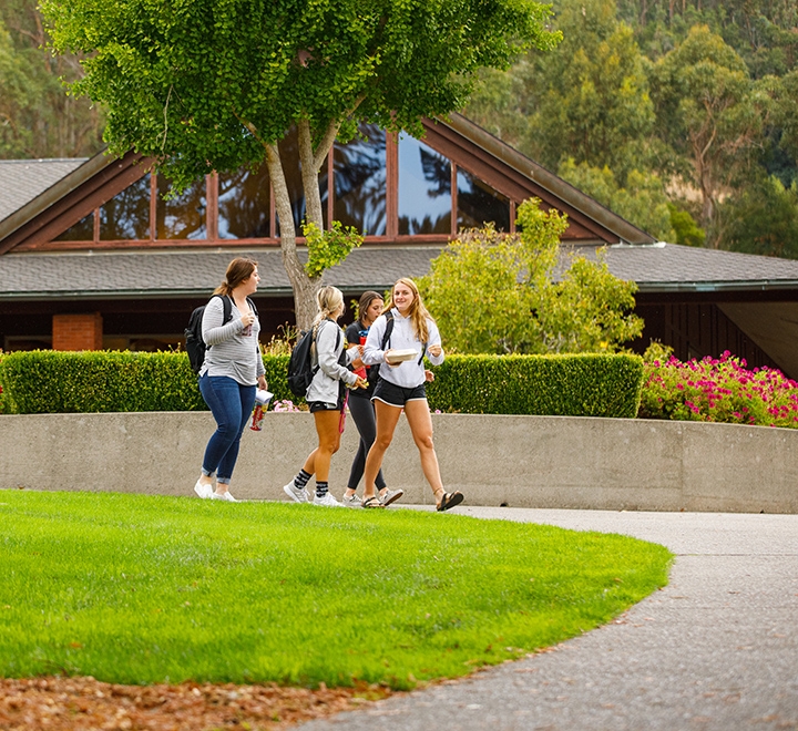 A group of students walks by Caleruega Dining Hall on the ֱ University of California campus.